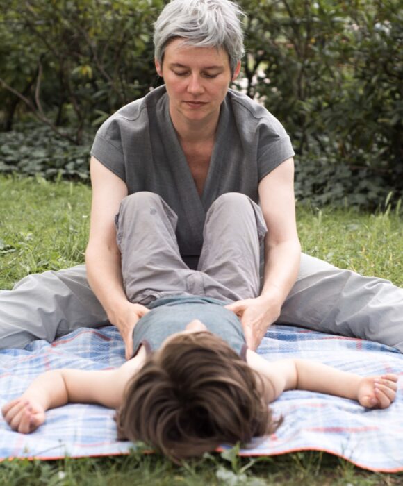 Kind liegend auf dem Rücken wird am Becken berührt,frühkindlichen Reflexe integrieren, Übungen